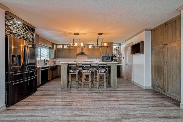 kitchen with an inviting chandelier, light countertops, light wood-type flooring, and appliances with stainless steel finishes