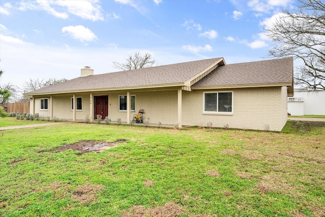 single story home featuring brick siding, a front lawn, a chimney, and a shingled roof