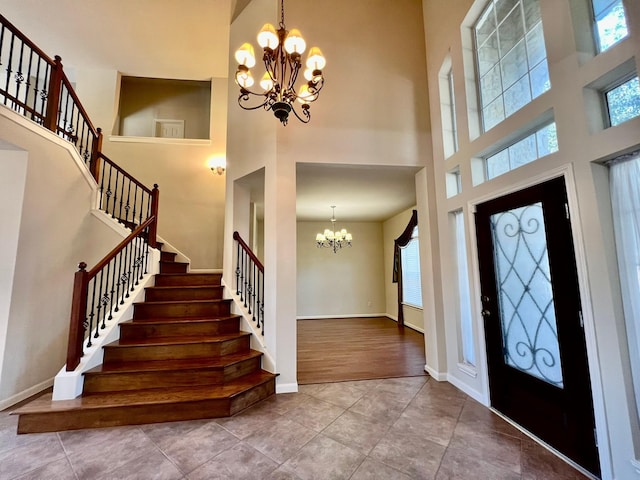 foyer entrance with a chandelier, plenty of natural light, and stairway