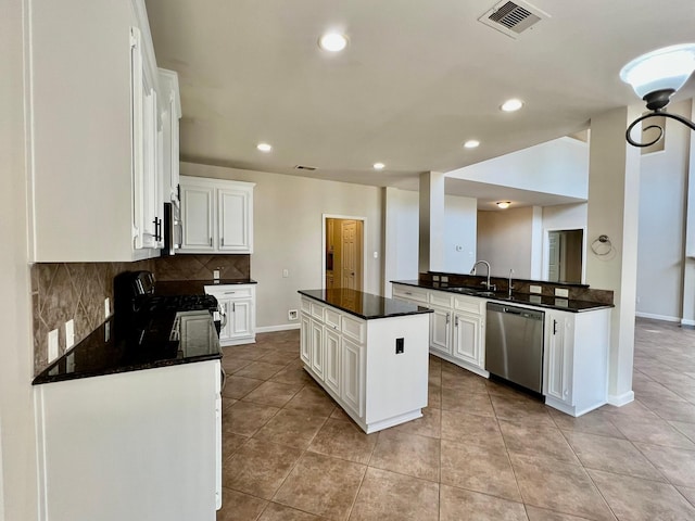 kitchen with visible vents, a sink, decorative backsplash, appliances with stainless steel finishes, and dark countertops