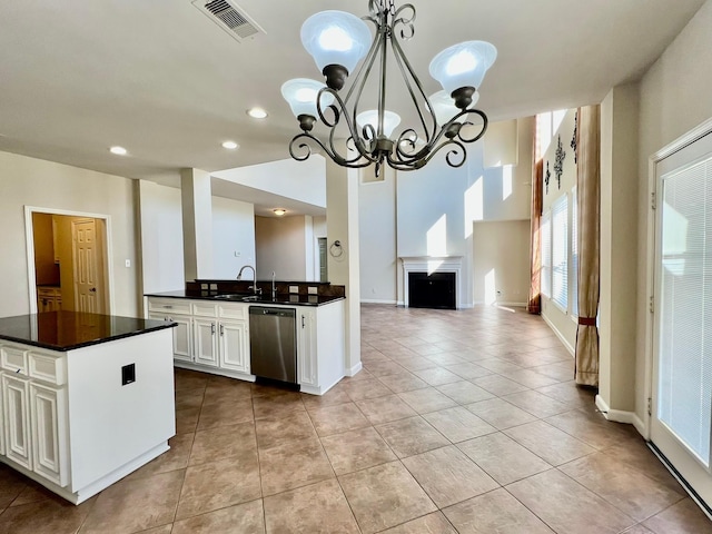 kitchen featuring dark countertops, visible vents, an inviting chandelier, white cabinetry, and stainless steel dishwasher