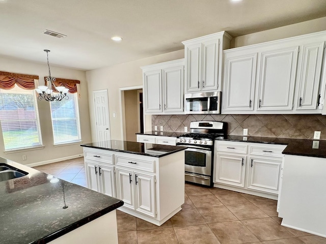 kitchen featuring light tile patterned floors, visible vents, appliances with stainless steel finishes, a chandelier, and a center island