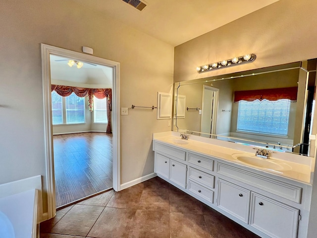 bathroom featuring tile patterned floors, double vanity, baseboards, and a sink