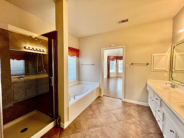 full bath with visible vents, double vanity, a sink, tile patterned flooring, and a garden tub