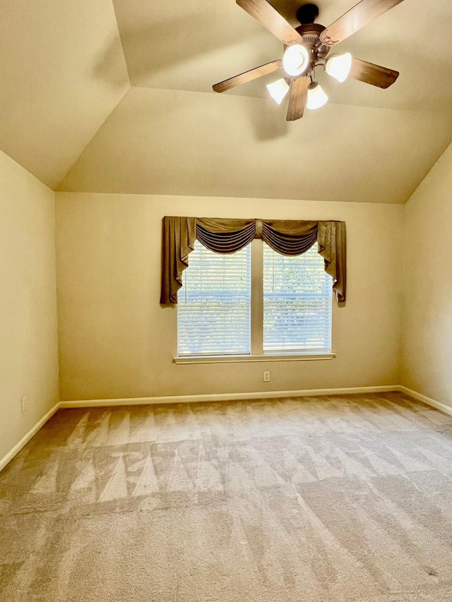 spare room featuring lofted ceiling, carpet flooring, and ceiling fan