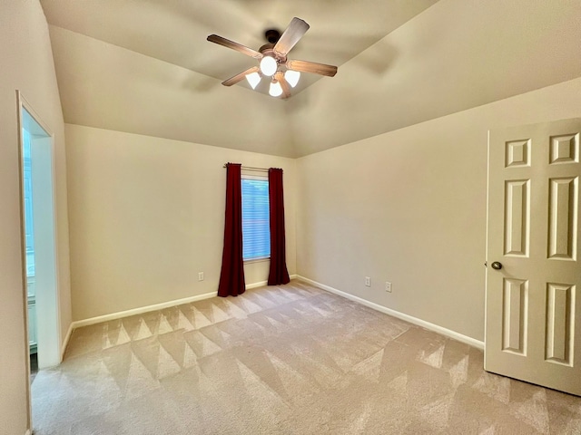 unfurnished room with lofted ceiling, a ceiling fan, light colored carpet, and baseboards