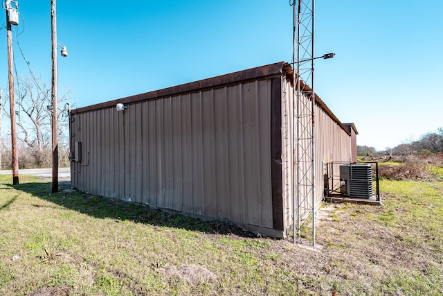 view of pole building with a yard and central AC unit