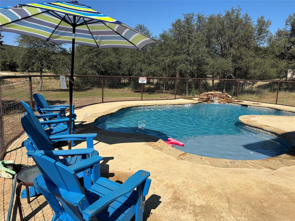 view of swimming pool featuring a fenced in pool and fence