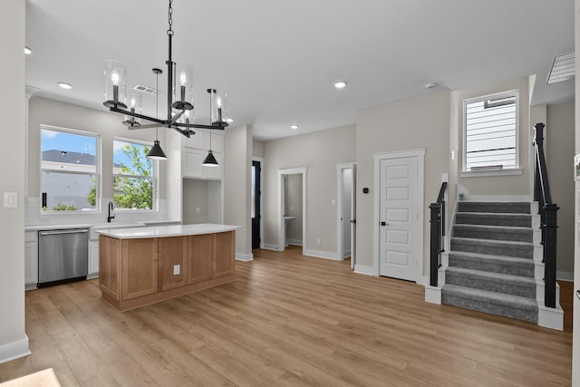 kitchen with recessed lighting, light countertops, stainless steel dishwasher, light wood-type flooring, and a center island