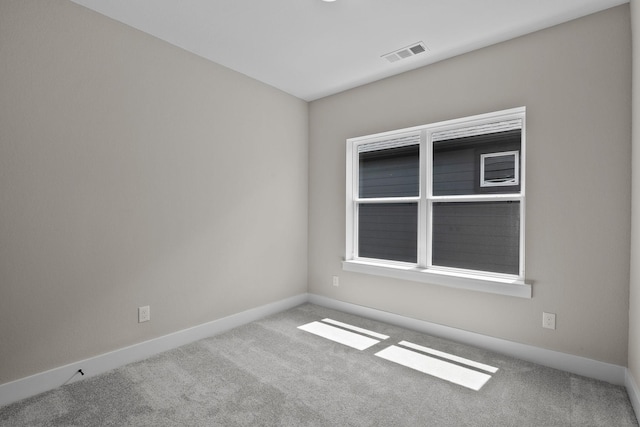 carpeted empty room with visible vents and baseboards