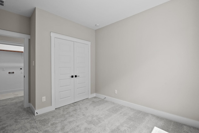 unfurnished bedroom with a closet, visible vents, baseboards, and carpet floors