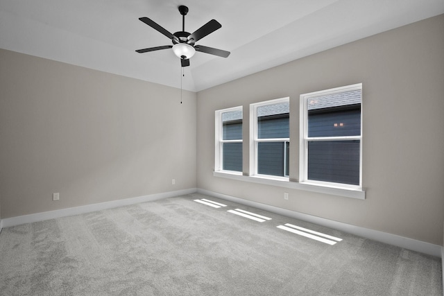 empty room with baseboards, carpet, ceiling fan, and vaulted ceiling