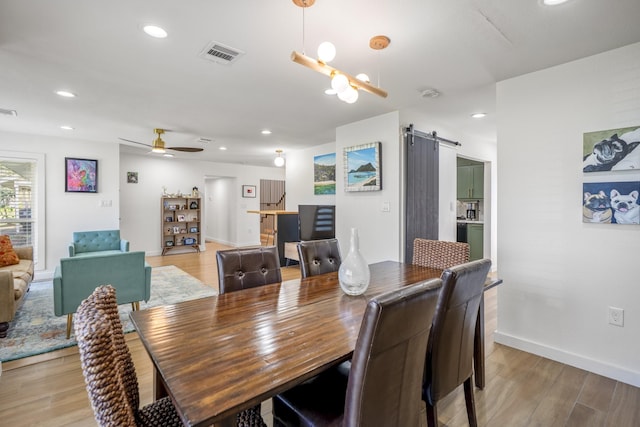 dining space featuring visible vents, a ceiling fan, recessed lighting, a barn door, and light wood finished floors