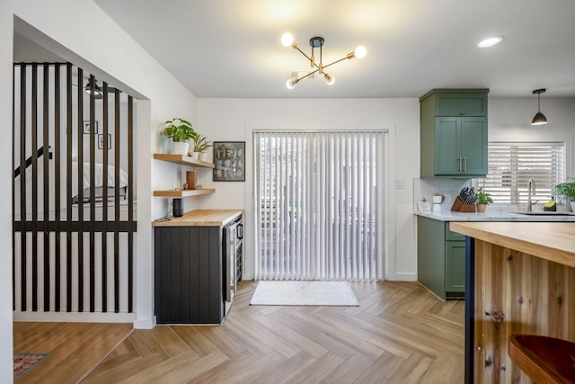 kitchen featuring wood counters, green cabinets, and a sink