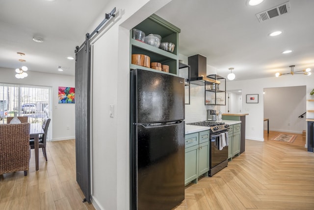 kitchen featuring visible vents, open shelves, freestanding refrigerator, green cabinetry, and stainless steel range with gas stovetop