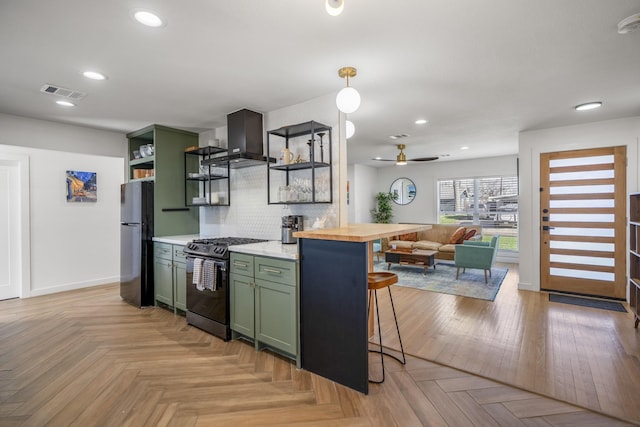 kitchen featuring visible vents, stainless steel gas stove, open shelves, freestanding refrigerator, and green cabinetry