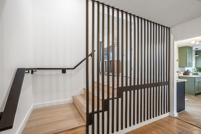 staircase featuring baseboards and wood finished floors