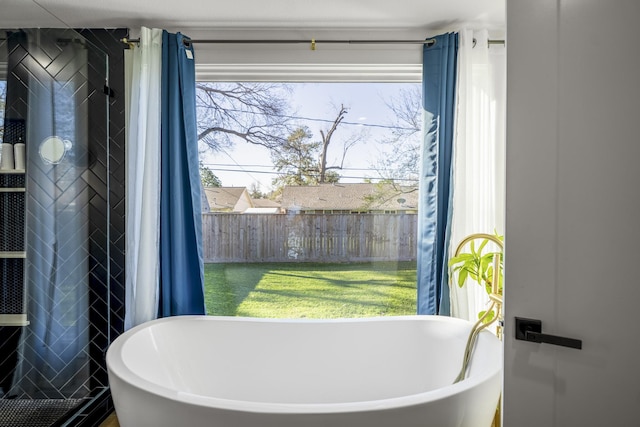 bathroom with a soaking tub and tile walls