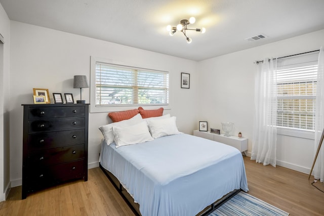 bedroom featuring visible vents, baseboards, and light wood-style floors