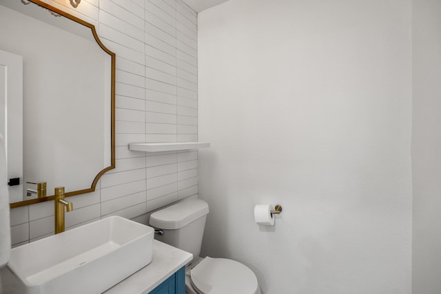 bathroom featuring vanity, tile walls, toilet, and tasteful backsplash