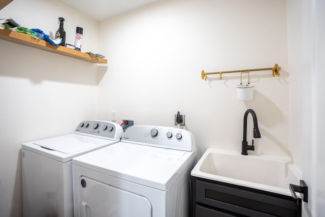 clothes washing area featuring washing machine and clothes dryer, cabinet space, and a sink