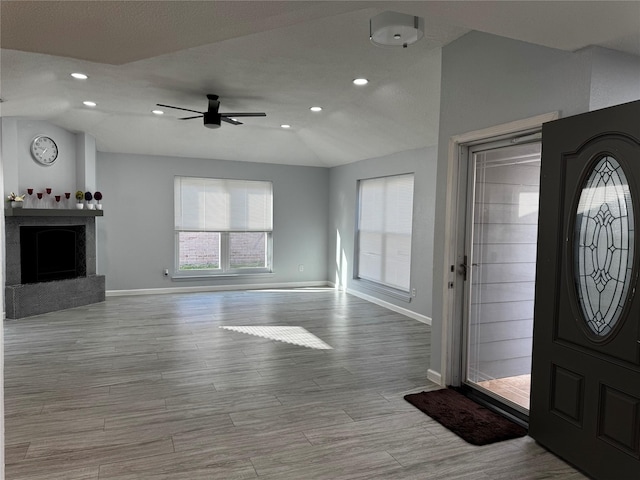 foyer with baseboards, wood finished floors, a ceiling fan, and vaulted ceiling