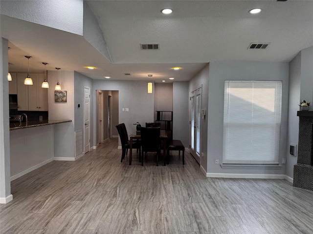 dining area featuring wood finished floors, visible vents, and baseboards