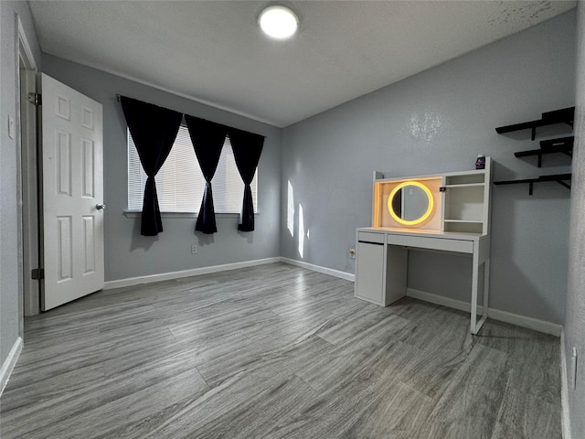 interior space featuring baseboards and wood finished floors