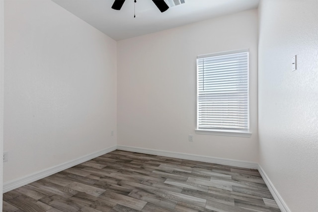 empty room featuring wood finished floors, a ceiling fan, and baseboards