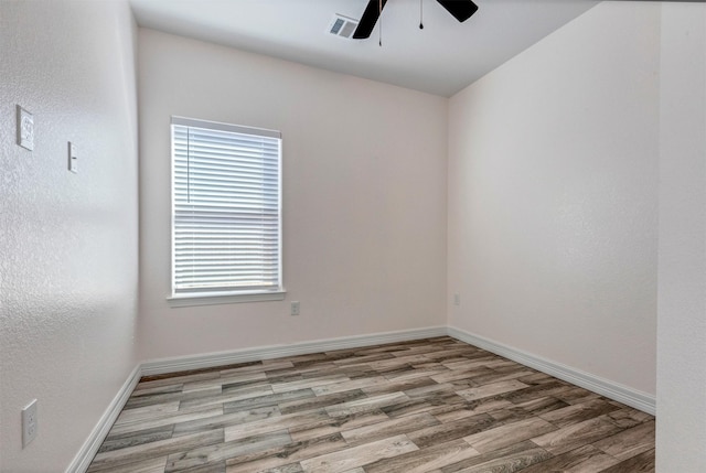 empty room featuring visible vents, light wood-style flooring, baseboards, and ceiling fan