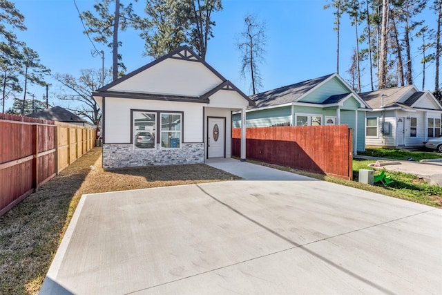 view of front of property featuring fence and stone siding