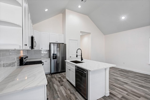 kitchen with light stone counters, a sink, light wood-style floors, appliances with stainless steel finishes, and white cabinetry