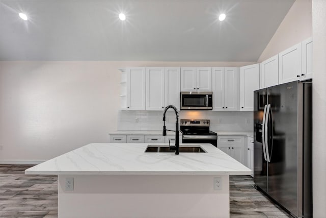 kitchen with lofted ceiling, open shelves, a sink, appliances with stainless steel finishes, and tasteful backsplash