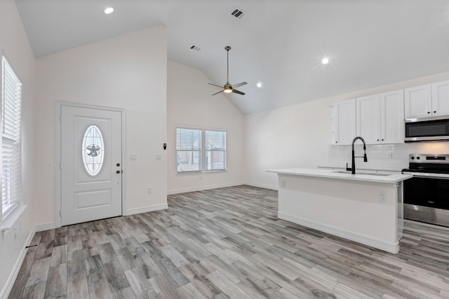 kitchen featuring a sink, light wood-style floors, appliances with stainless steel finishes, and light countertops