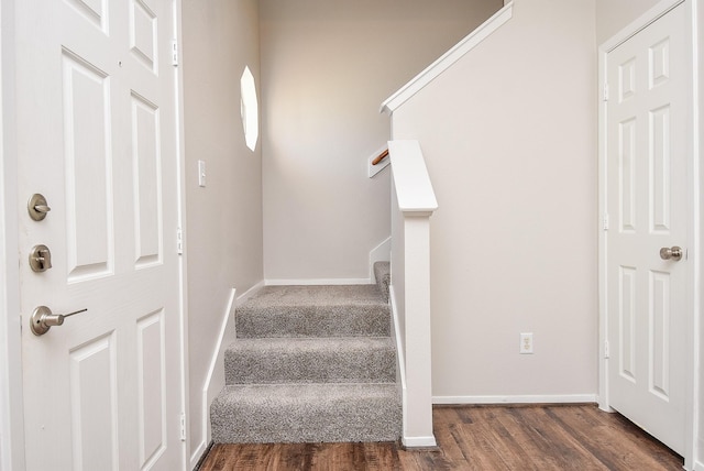 staircase with baseboards and wood finished floors