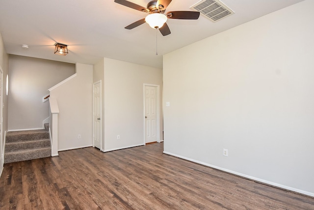 unfurnished living room featuring visible vents, baseboards, stairway, a ceiling fan, and dark wood-style flooring