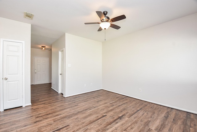 spare room featuring baseboards, wood finished floors, visible vents, and ceiling fan