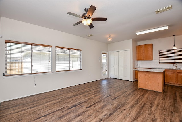 interior space featuring visible vents, dark wood-type flooring, light countertops, decorative backsplash, and a sink