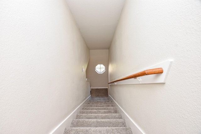 staircase featuring carpet and baseboards