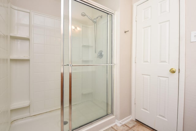 full bathroom featuring a stall shower and baseboards