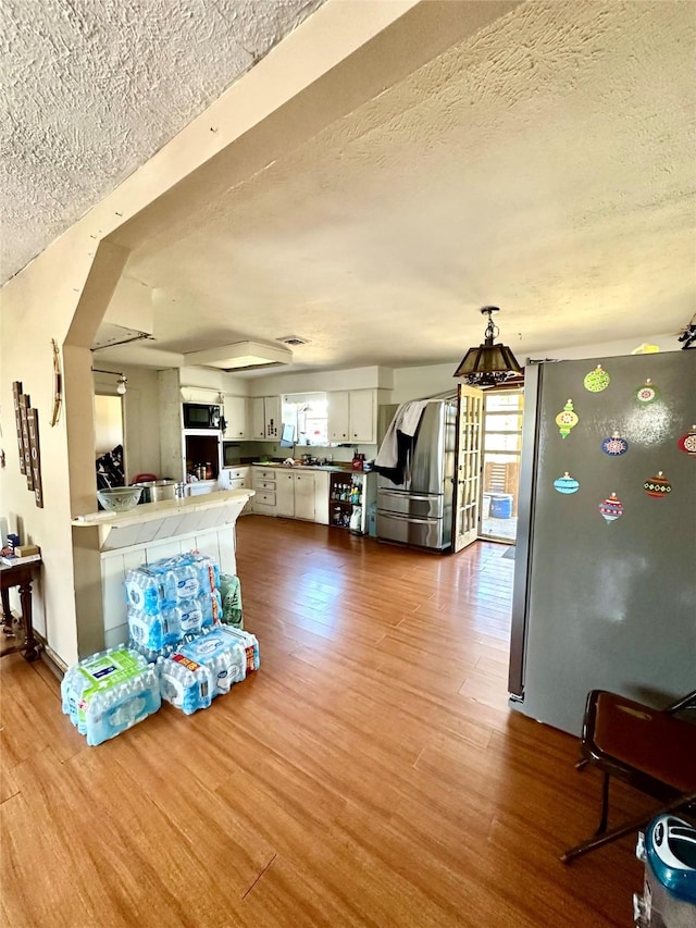 living area featuring a textured ceiling and wood finished floors