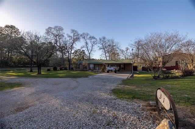 view of front of home featuring a carport, a front lawn, and driveway