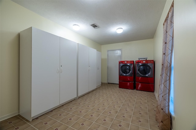 laundry room featuring a textured ceiling, laundry area, visible vents, and washer and clothes dryer