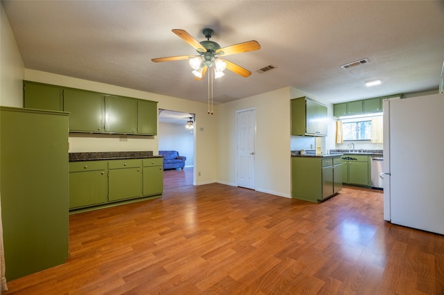 kitchen featuring ceiling fan, visible vents, green cabinets, and freestanding refrigerator