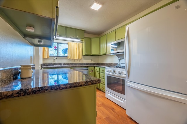 kitchen featuring green cabinetry, light wood-type flooring, stainless steel appliances, a textured ceiling, and a sink