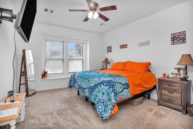 carpeted bedroom featuring baseboards, visible vents, and ceiling fan