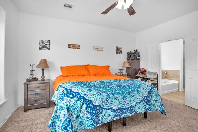 bedroom featuring ensuite bath, carpet, visible vents, and ceiling fan