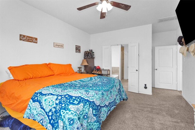 carpeted bedroom featuring a ceiling fan, visible vents, and connected bathroom