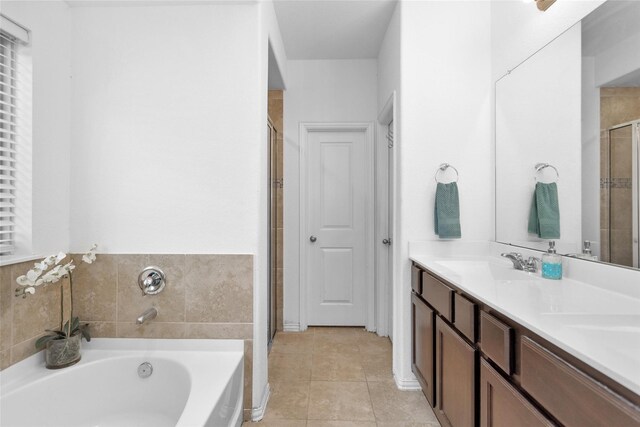 full bathroom featuring a garden tub, a sink, a shower stall, tile patterned flooring, and double vanity