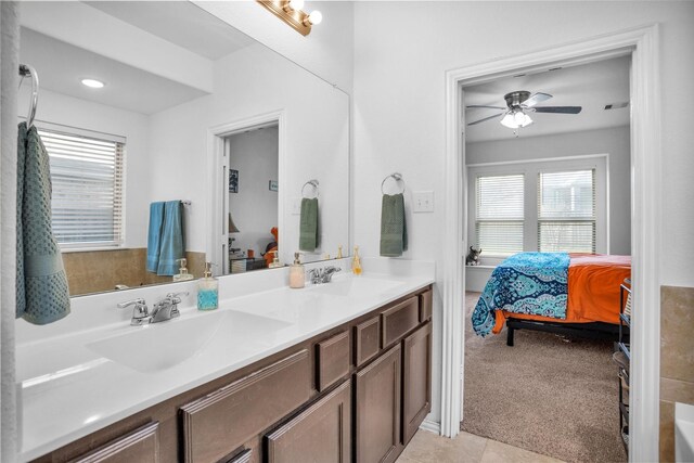 bathroom with a sink, a ceiling fan, double vanity, and ensuite bathroom